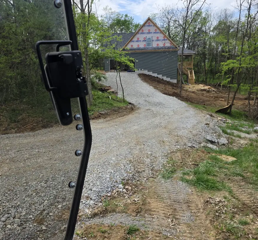 Gravel drive curving up to a house under construction