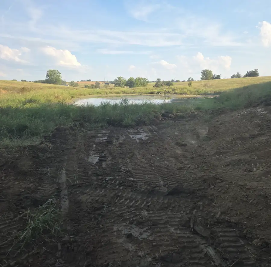 Graded dirt bank leading down to a pond
