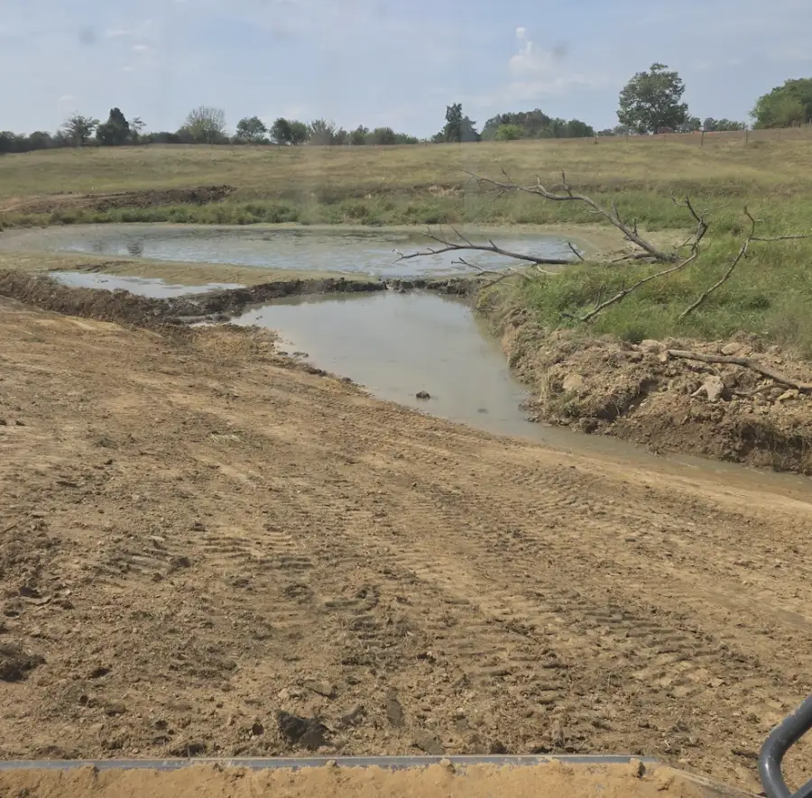 Freshly dug pond with shaped banks holding water